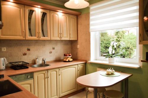 a kitchen with a sink and a table and a window at Mieszkanie Nad Morzem in Ustka