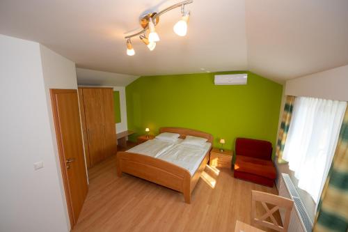 ein Schlafzimmer mit einem Bett und einer grünen Wand in der Unterkunft Dorfzeit-Fleischhacker in Apetlon
