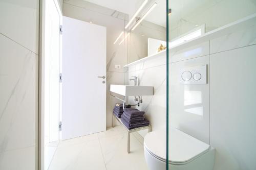 biała łazienka z toaletą i umywalką w obiekcie Casa Bela w mieście Klimno