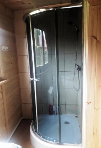 a shower with a glass door in a bathroom at morska chata in Lubiatowo