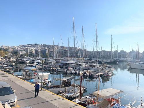 a man standing on a dock with boats in a marina at ARIS Piraeus- Sailor's friend in Piraeus