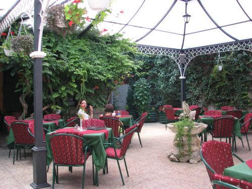 un restaurant en plein air avec des tables, des chaises et un parasol dans l'établissement Villa Gurman 024, à Bačka Topola