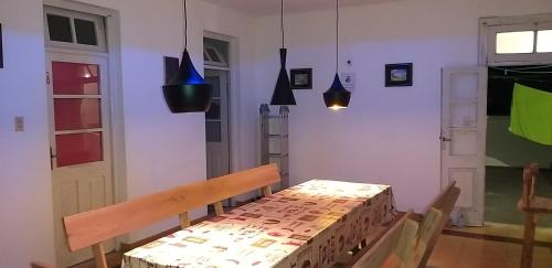 comedor con mesa y luces colgantes en Hostal, home sweet home, en Salto