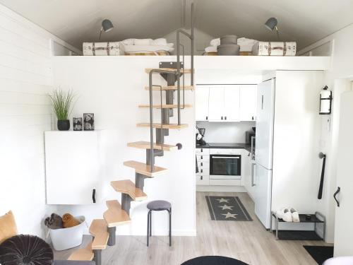 une petite cuisine avec un escalier en colimaçon dans une petite maison dans l'établissement Humlegarden lake cottage, Horn, à Horn