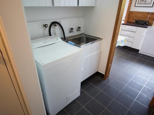 a kitchen with a sink and a washing machine at Kanuka House - Kaiteriteri Holiday Home in Kaiteriteri