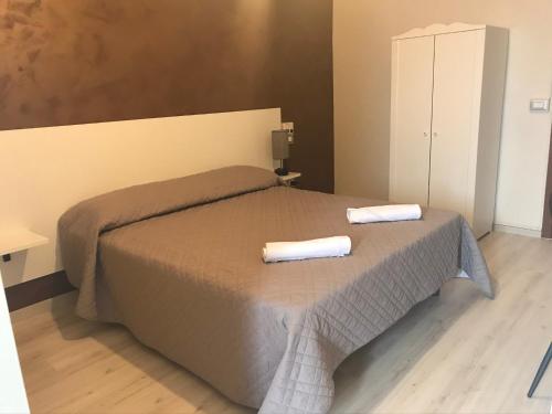 a bedroom with a bed with two towels on it at Albergo Ristorante Uspa in Gorino Ferrarese