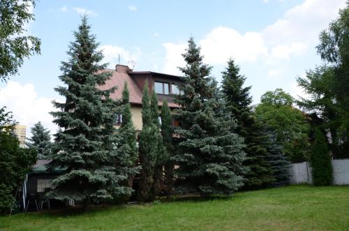 dom z drzewami przed nim w obiekcie Kwatery Pracownicze TOLEK w Warszawie