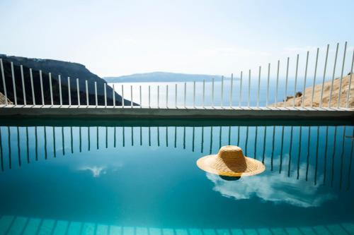 a straw hat sitting on top of a swimming pool at Lilium Hotel Santorini in Fira