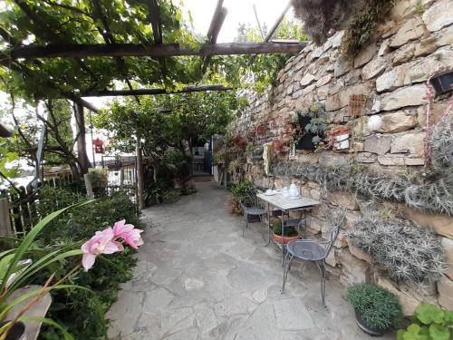 a patio with a table and chairs next to a stone wall at ca del pescatore in Cervo
