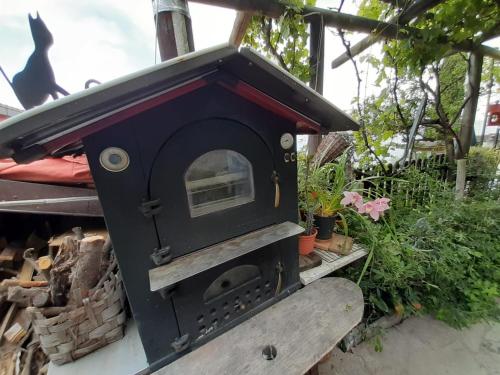 a black wood fired oven sitting in a garden at ca del pescatore in Cervo