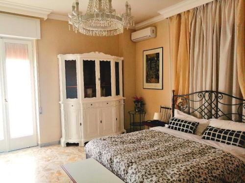 una camera con letto e lampadario a braccio di Residenza Carlo di Borbone a Caserta
