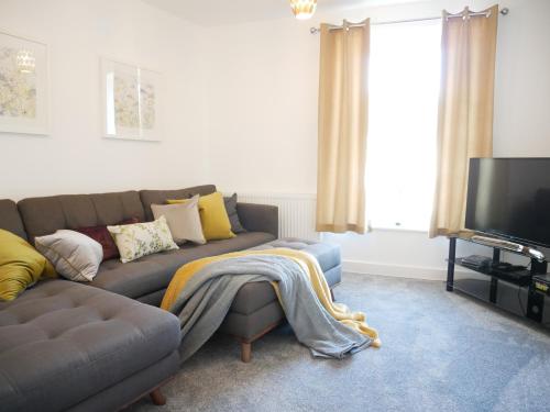 a living room with a couch and a tv at The Gill Gardens Penthouse, Ulverston - Lake District in Ulverston