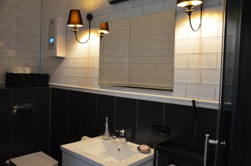 un bagno con lavandino, specchio e WC di Przy Rynku Black and White a Tarnowskie Góry