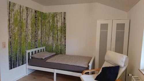 une petite chambre avec un lit et une chaise dans l'établissement Ferienhaus Möwe, à Butjadingen