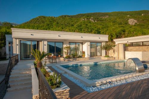 uma casa com piscina em frente a uma casa em Villa Salute em Budva