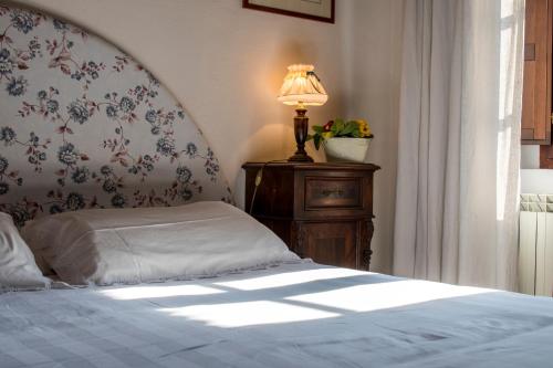 a bedroom with a bed and a lamp on a table at Agriturismo Pometti - Fattoria La Selva in Trequanda