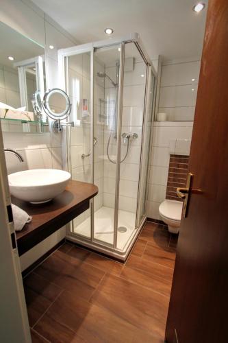 a bathroom with a glass shower and a sink at Gästehaus Fels in Riezlern
