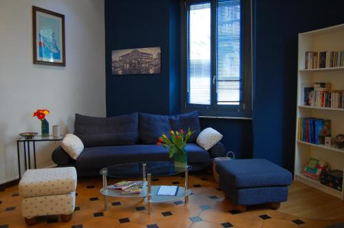 ein Wohnzimmer mit einem blauen Sofa und einem Tisch in der Unterkunft Colazione da Augusta - Guesthouse in Turin