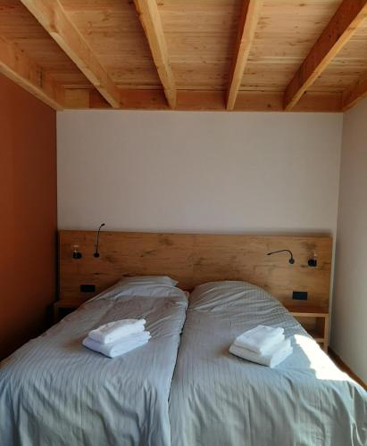 two twin beds in a room with wooden ceilings at Slaperij Salud! Studios & appartementen in Scharendijke