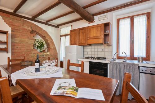 a kitchen with a wooden table with a bottle of wine at Agriturismo Pometti - Fattoria La Selva in Trequanda