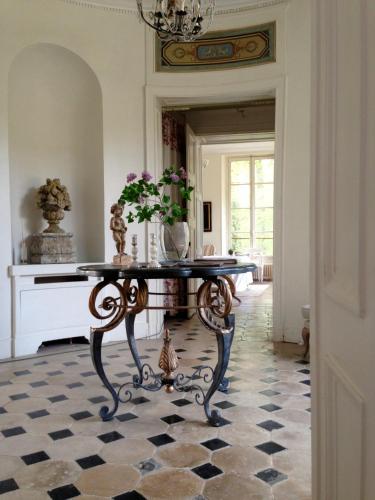 - une chambre avec une table et des fleurs au sol dans l'établissement Domaine et Château de Séréville, à La Belliole