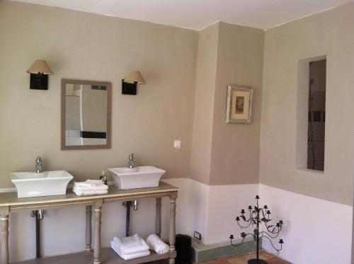 a bathroom with two sinks and two mirrors at Domaine et Château de Séréville in La Belliole