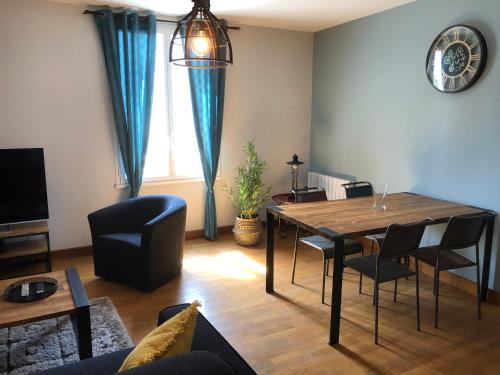 un salon avec une table, des chaises et un canapé dans l'établissement Au Coeur du Marché 4 étoiles, à Fécamp