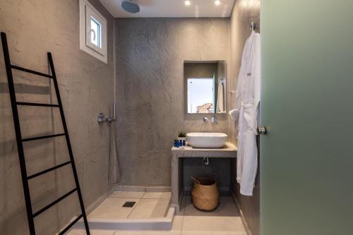 a bathroom with a sink and a mirror at Sunset Paraportiani Rooms in Mýkonos City
