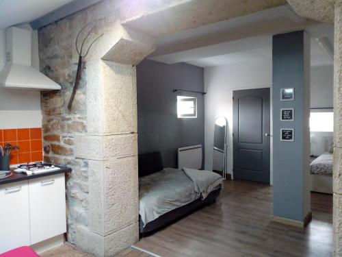 Habitación con cama y pared de piedra. en Le Gîte du haut en Châtillon-la-Palud
