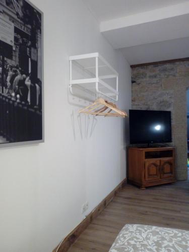 a room with a flat screen tv and a tv stand at Le Gîte du haut in Châtillon-la-Palud