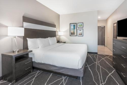 a hotel room with a bed and a television at La Quinta Inn and Suites by Wyndham Houston Spring South in Spring