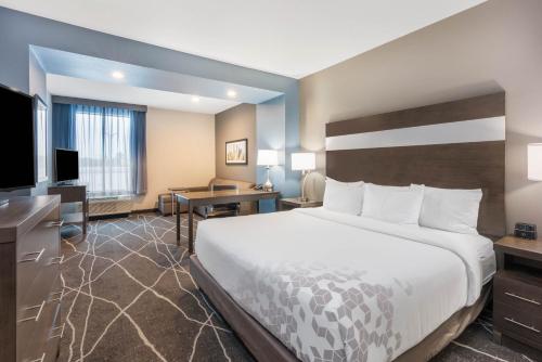 a hotel room with a large bed and a desk at La Quinta Inn and Suites by Wyndham Houston Spring South in Spring