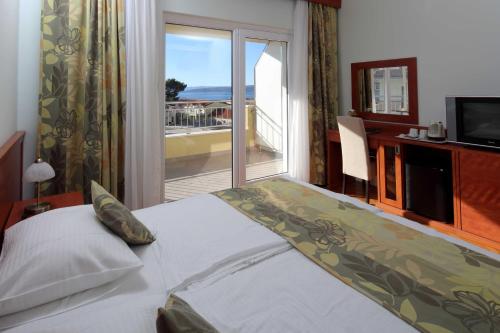 sypialnia z łóżkiem i widokiem na ocean w obiekcie Dorijini Dvori w Baskiej Vodzie