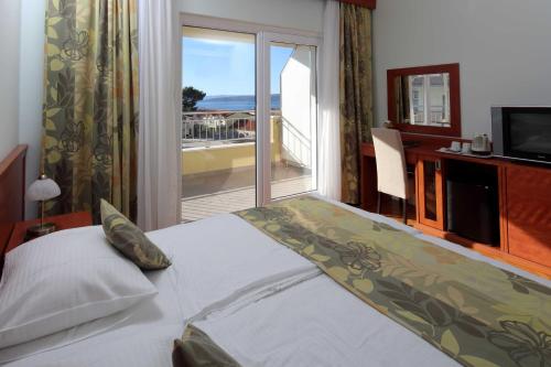 a bedroom with a bed with a view of the ocean at Dorijini Dvori in Baška Voda