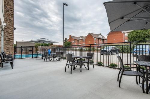 a patio with tables and chairs and a fence at Holiday Inn Express & Suites Dallas North - Addison by IHG in Addison
