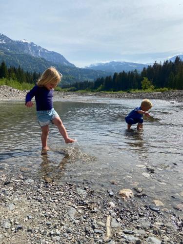 two children playing in the water in a river at Gästehaus Nassfeld in Tröpolach