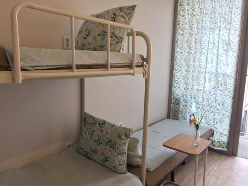 Habitación pequeña con litera y mesa en Inside Busan Hostel, en Busan
