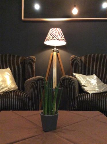 um candeeiro num quarto com duas cadeiras e uma planta em Boutique Hotel Butler em Zuienkerke