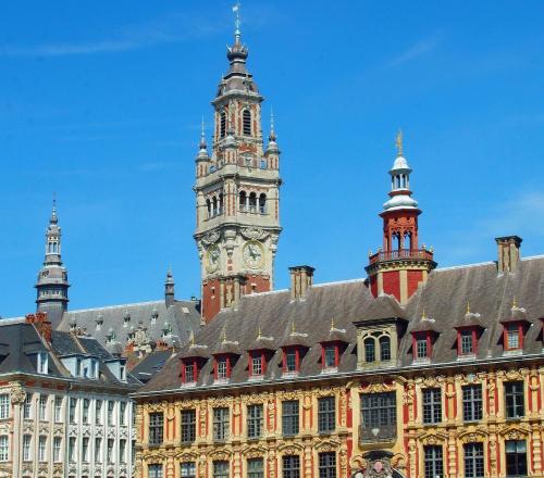 a building with a clock tower on top of it at Novotel Lille Aéroport in Lesquin