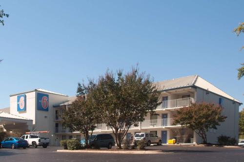 a hotel with cars parked in front of it at Motel 6-Raleigh, NC - Cary in Cary