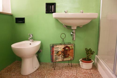 baño verde con lavabo y aseo en Ritornello B&B, en Poviglio