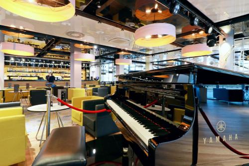 a piano in a room with chairs and lights at Hotel Hamilton SPA & Wellness in Świnoujście