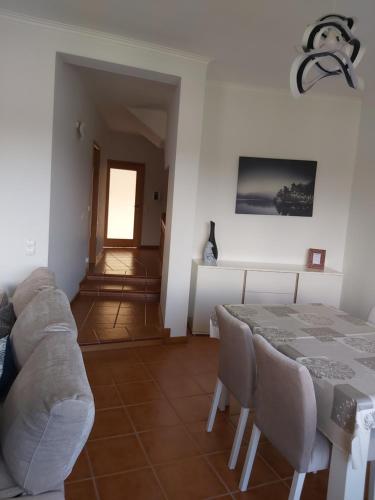 a dining room with a table and a couch at Ulfilanis Vila in Fiães