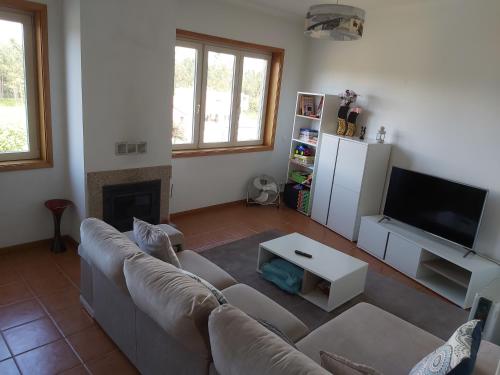 a living room with a couch and a fireplace at Ulfilanis Vila in Fiães