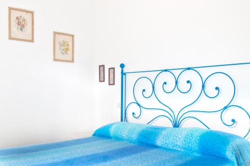 ein Schlafzimmer mit einem blauen Bett mit einem Kopfteil aus Metall in der Unterkunft Cedro del Libano in Castiglioncello