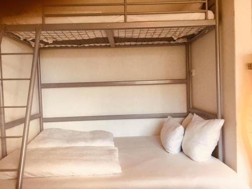 a bunk bed with two white pillows on it at Nice room in apartment in Amager in Copenhagen