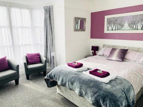 a bedroom with a large bed and two chairs at Cambrian House in Llangollen