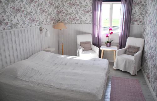 sypialnia z łóżkiem, 2 krzesłami i oknem w obiekcie Galleri Blå Porten w Alby