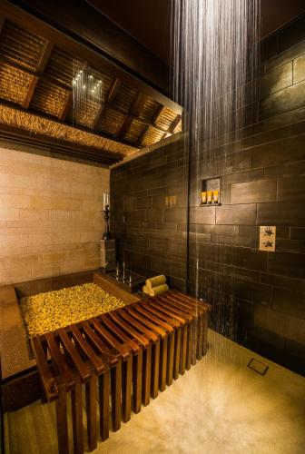 a bath room with a bench and a shower at The Legian Seminyak, Bali in Seminyak