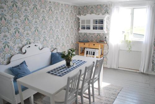 ein Esszimmer mit einem weißen Tisch und Stühlen in der Unterkunft Galleri Blå Porten in Alby
